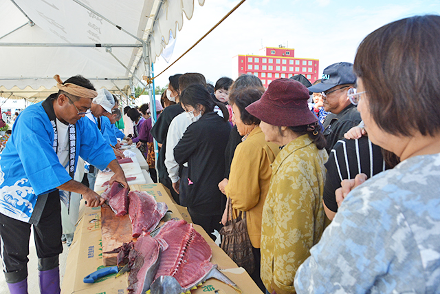 マグロの解体ショーに行列する来場者