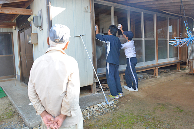 中学生と教員の作業を笑顔で見守る住人