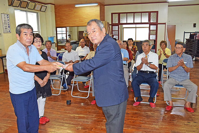 実吉悟区長へ目録を渡す里村勝志さんの両親