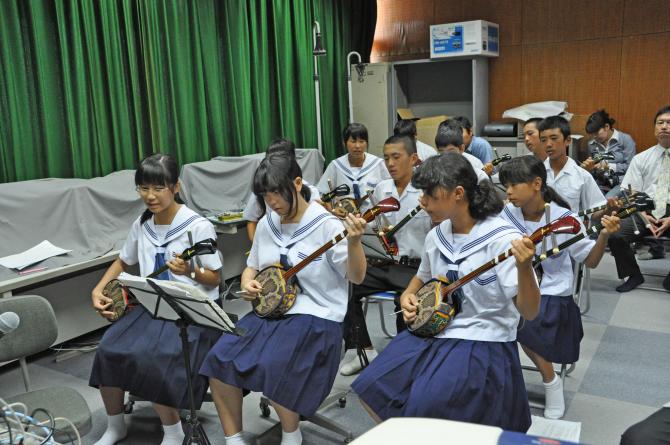 三線を演奏し「徳之島小唄」を合唱する中学生