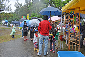 雨のなか屋台の買い物を楽しむ来場者