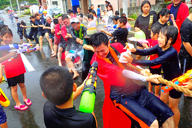 綱引き中に容赦なく水をかける子どもたち