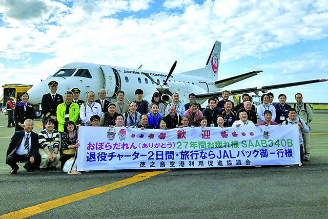 徳之島空港駐機場で乗客がサーブ機と記念撮影