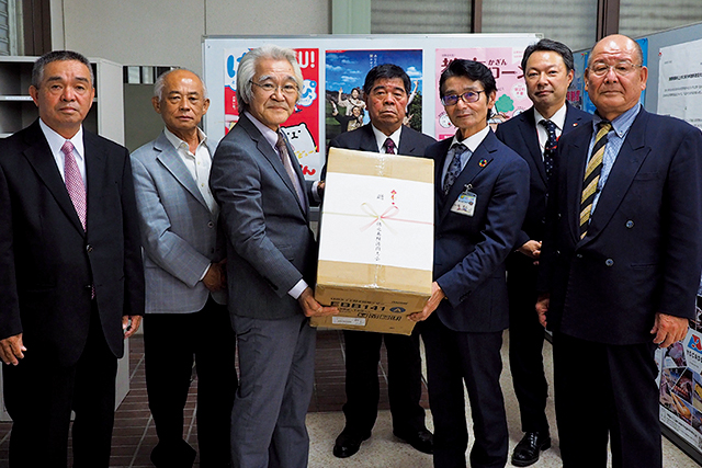 防犯ブザーを手渡す吉川会長（左から3番目）