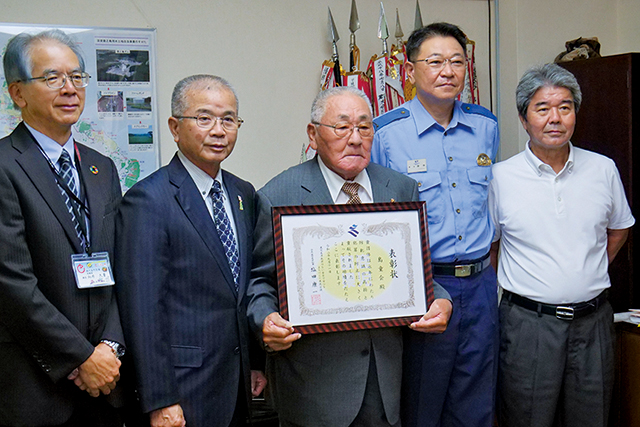 表彰を受けた島童会代表の宮永勇夫さん（写真中央）