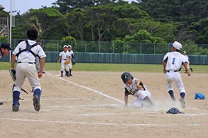 ホームにスライディングする亀津ライオンズの選手