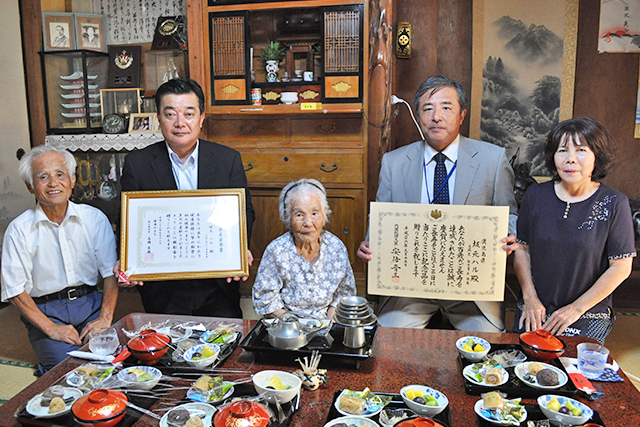 家族に囲まれて笑顔の坂元ハルさん（中央）