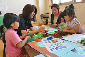 折り紙で鯉のぼりを折る親子連れ