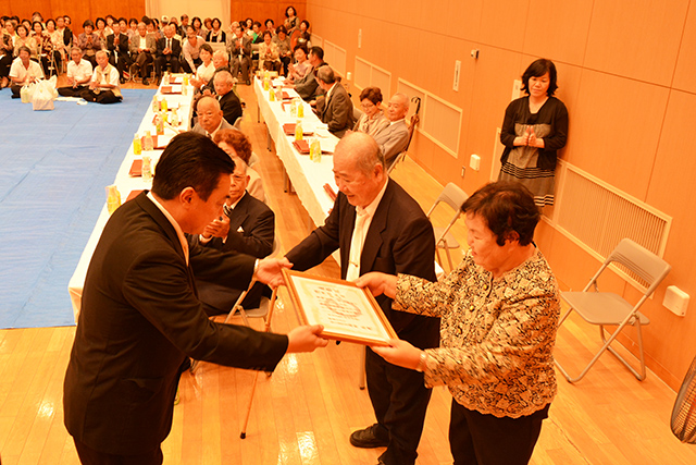 表彰状を受け取る徳田昭弘さん、洋子さん夫婦