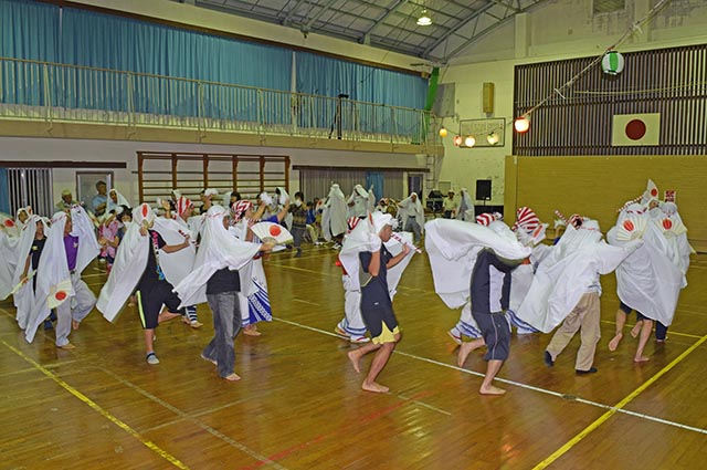 男女が輪になりアンゴー踊りを披露